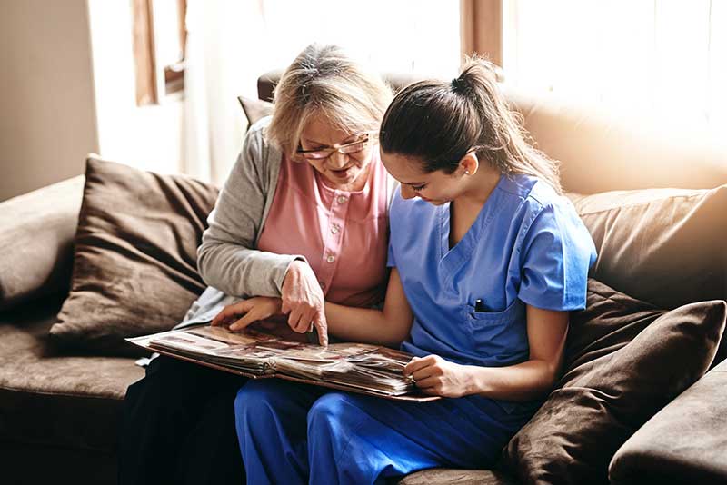 Woman and nurse looking at photo album