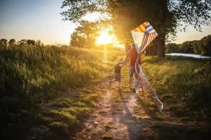 Man and child running and flying a kite